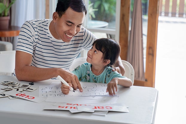 Dad supporting a child's phonics learning