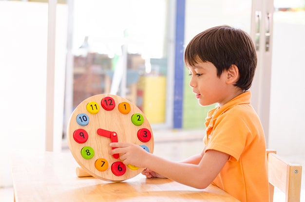 kid using a play clock to learn and tell time