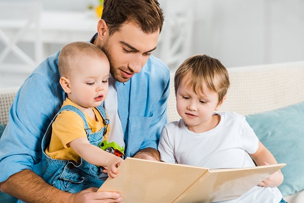 Dad and two kids working on print awareness