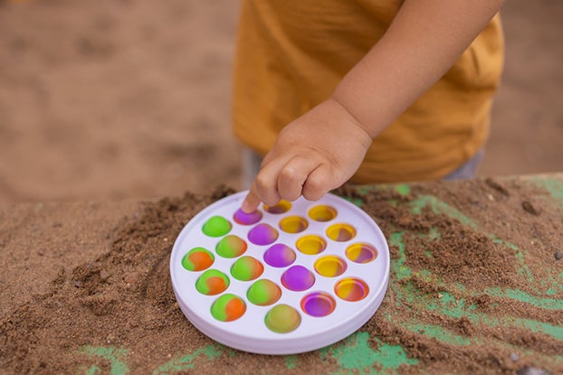 kid playing with popping toy