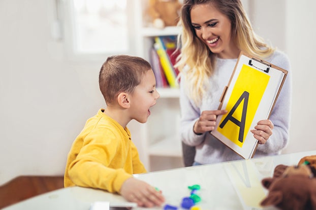 Speech therapist teaches the boys to say the letter A