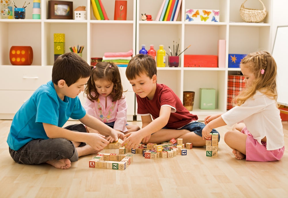 Kids learning through playing with blocks on the floor