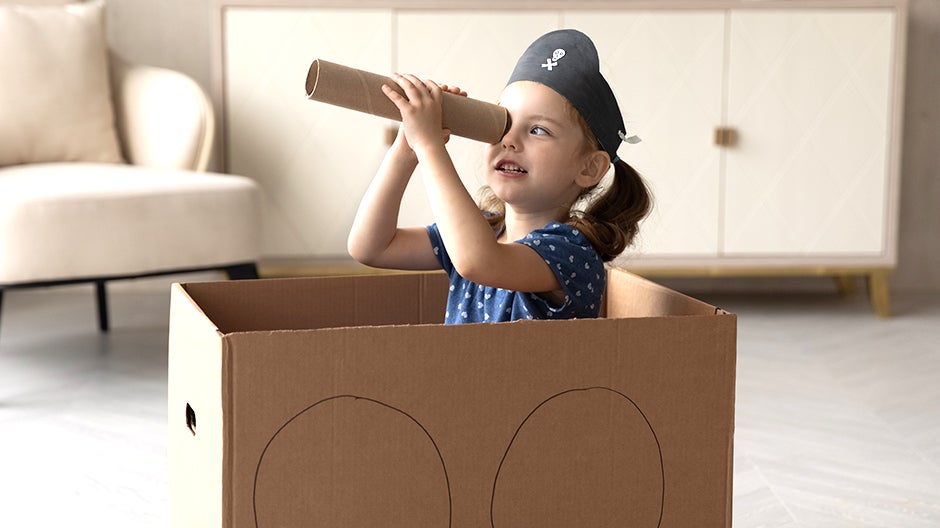 Kid playing phonemic awareness I Spy in a cardboard box