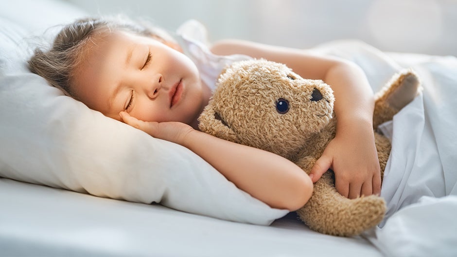 Child sleeping with stuffed animal to help calm emotions