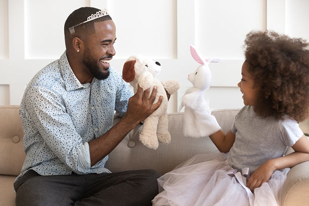 Dad doing pretend play with young daughter