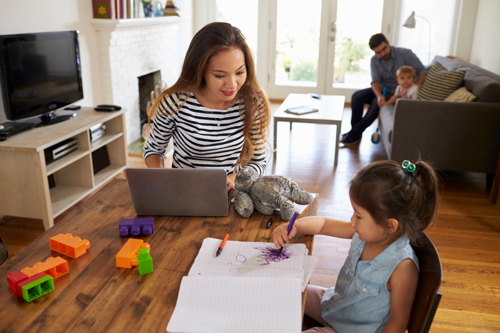 Mom searching for activities for 3-year-olds while her daughter draws