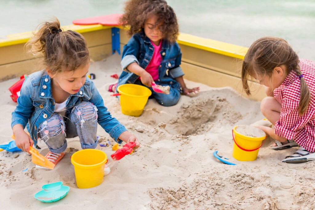 sisters playing in the sand