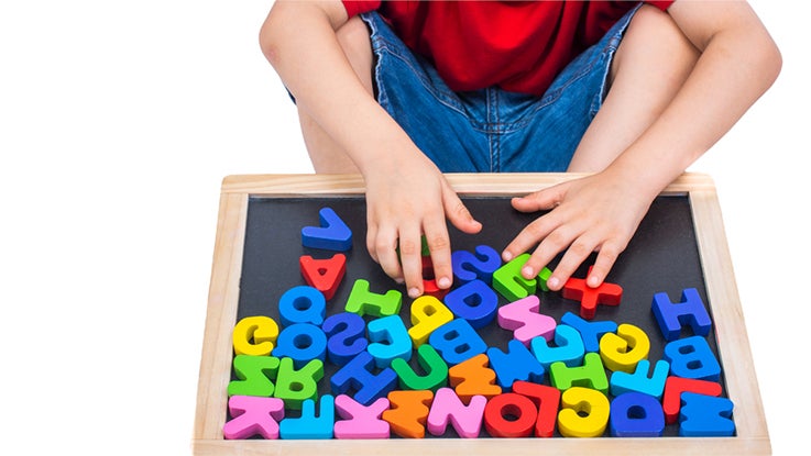 kid building a word with plastic letters