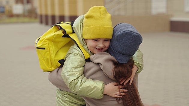 Mom hugging kid before heading to school